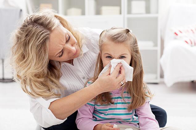 A mother helping her daughter with allergy symptoms at home